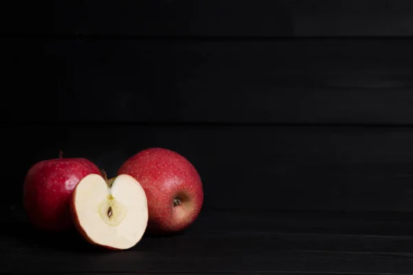 Ganze Und Scheiben Geschnittene Rote Äpfel Auf Einem Dunklen Holztisch — Stockfoto