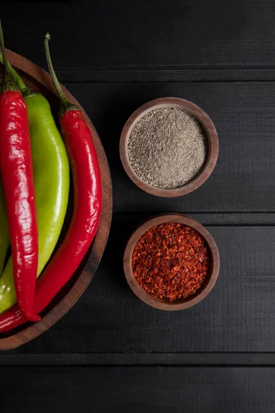 Kırmızı ve yeşil acılı biberler ahşap bir kasede baharatlı. Yüksek kalite fotoğraf