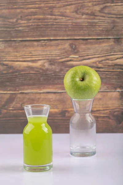 Una Manzana Verde Entera Con Una Jarra Jugo Sobre Fondo —  Fotos de Stock