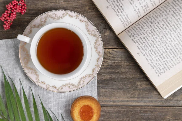 cup of tea and a book on a wooden background