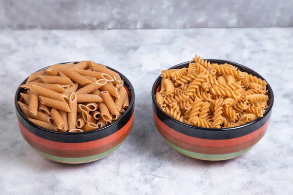 Bowls Full Uncooked Penne Rigate Fusilli Pasta Placed Marble Background — Stock Photo, Image