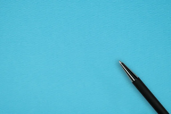 青い紙の背景に黒ボールペン — ストック写真