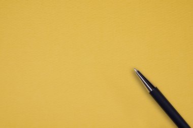 Sarı kağıt arka plan üzerinde siyah topu kalem