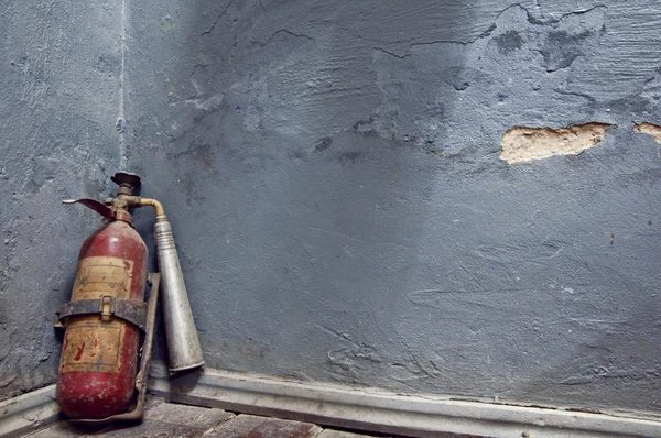 Fire extinguisher near  the wall — Stock Photo, Image