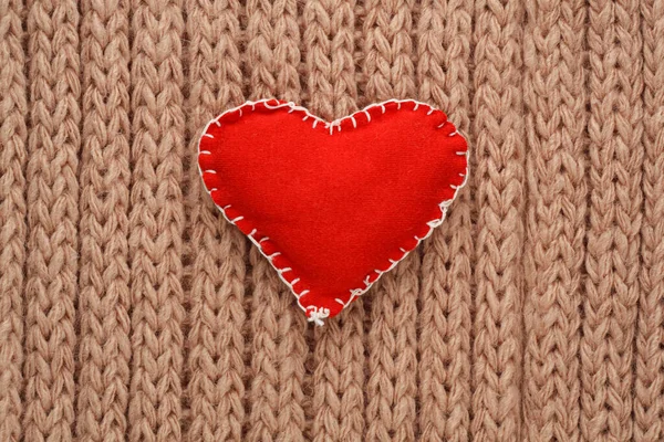ニットの背景にファブリックから縫い付けられた赤いハート。バレンタインカード — ストック写真