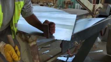 Tinsmith inşaat atölyesinde galvanize metalle çalışıyor..