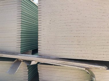 İnşaat alanında yığınla alçıpan var. Yığınla alçıdan çarşaf. Alçı taşı kartonu