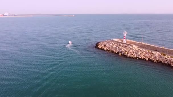 Man in a motor boat leaves the harbor. Aerial view footage — Stock Video