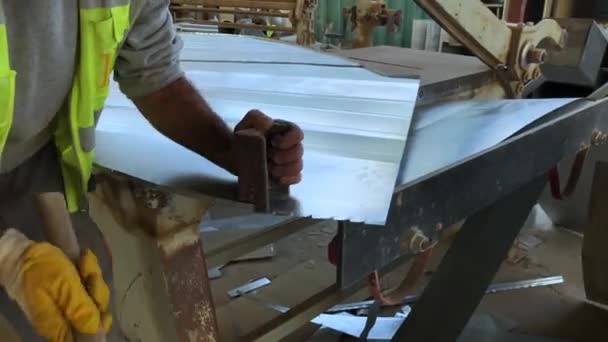 Tinsmith arbetar med en plåt av galvaniserad metall på byggarbetsplatsen verkstad — Stockvideo