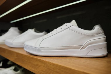 Ayakkabı mağazasının rafında boş beyaz spor ayakkabıları.