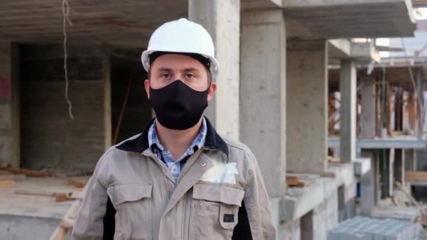 Trabajador de la construcción con pancarta Desempleado frente a la obra — Vídeo de stock