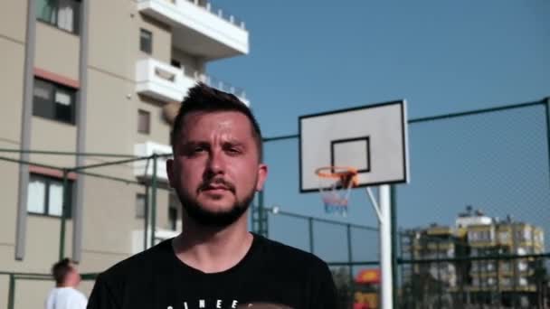 Mannen snurrar basket på sitt finger — Stockvideo