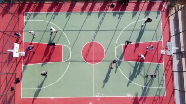 Erkekler hava sahasında sokak basketbolu oynuyorlar.