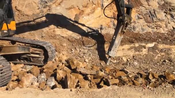 Excavator with hydraulic hammer crushes rocky soil — Stock Video