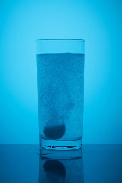 La compressa effervescente si scioglie in un bicchiere d'acqua — Foto Stock