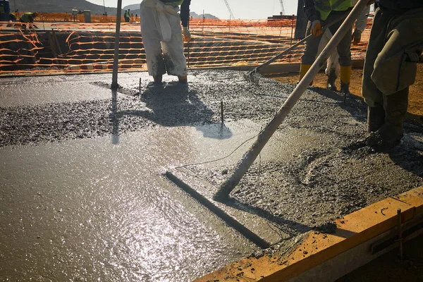 Stavební dělníci úroveň čerstvě litý beton s býčí plovák — Stock fotografie