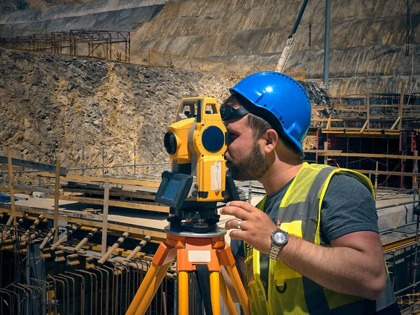 Land surveyor works at construction site