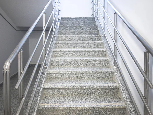 Empty stairway with chrome colored handrails at industrial prefabricated building