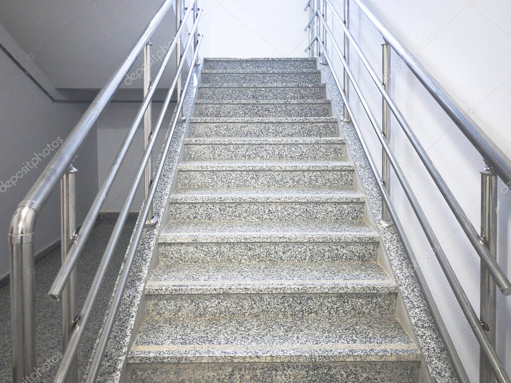 Empty stairway with chrome colored handrails at industrial prefabricated building