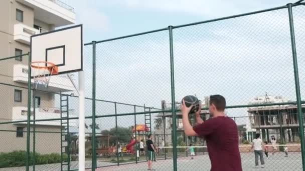 El hombre lanza baloncesto a un aro — Vídeo de stock