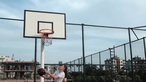 Мужчина бросает баскетбол на ринг — стоковое видео