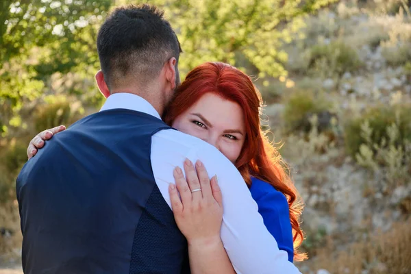 Vrouw knuffelt haar geliefde man op zoek naar een camera — Stockfoto