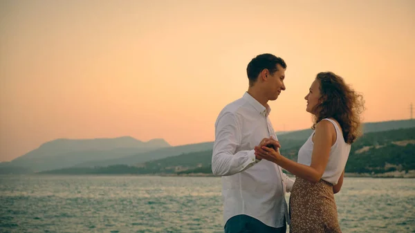 Man en vrouw hand in hand aan zeekust — Stockfoto