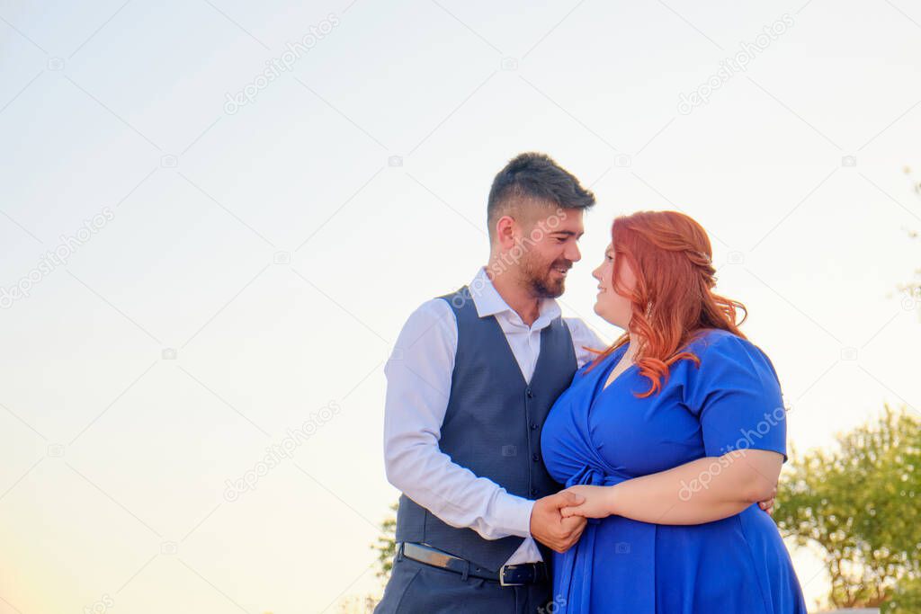 Man and woman look to each other embracing