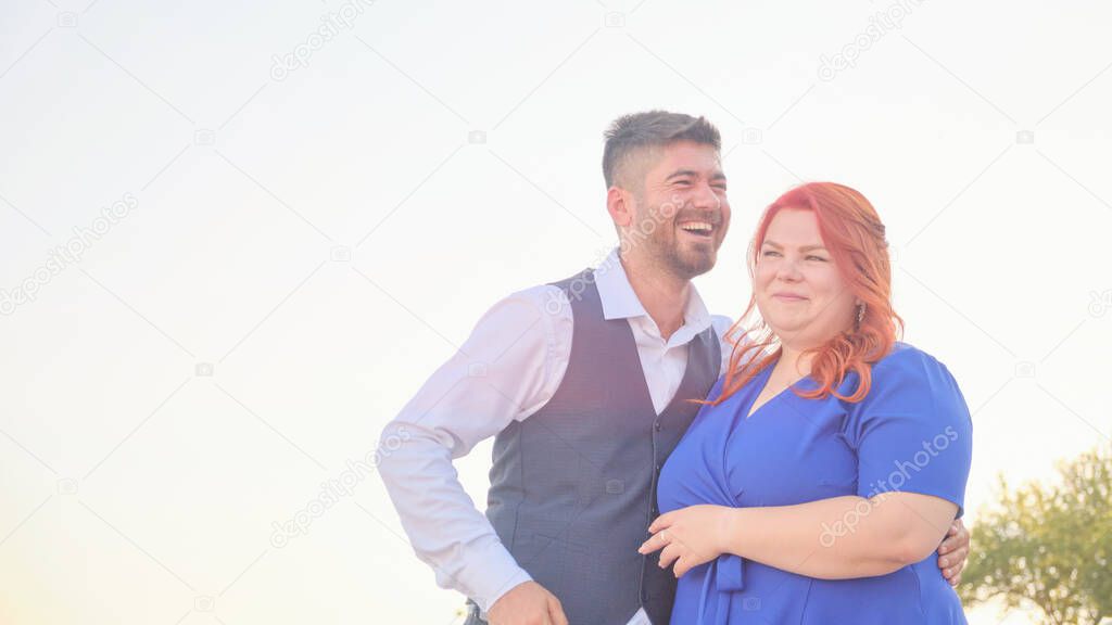 Man hugs his beloved woman smiling