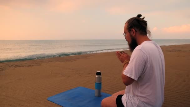 Mężczyzna pije herbatę na plaży — Wideo stockowe