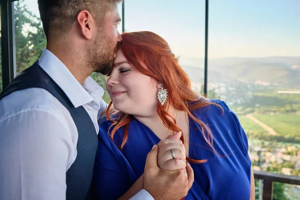 Esposo besa a su esposa mostrando anillos de boda en los dedos — Foto de Stock