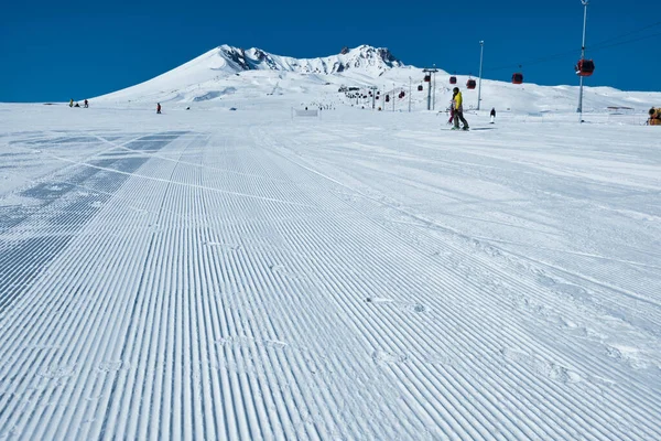 Snow groomer tracks on ski slope