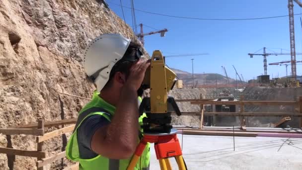 Land surveyor works on optical instrument — Stock Video