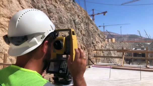 Land surveyor works on optical instrument — Stock Video