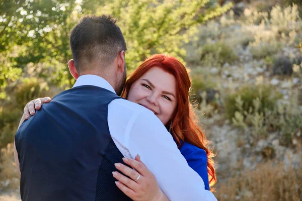 Vrouw knuffelt haar geliefde man op zoek naar een camera — Stockfoto