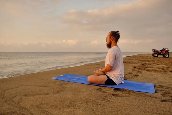 Мужчина медитирует на пляже — стоковое фото