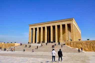 Ankara, Türkiye 'deki Mustafa Kemal Atatürk anıtı Anitkabir' in geniş açılı manzarası. Uzun kolonları, geniş taş basamakları ve meydanda yürüyen ziyaretçileri olan neoklasik mimari