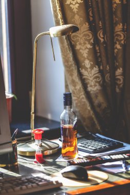 Şişe alkol ve kum saati üstünde senin okul sırası