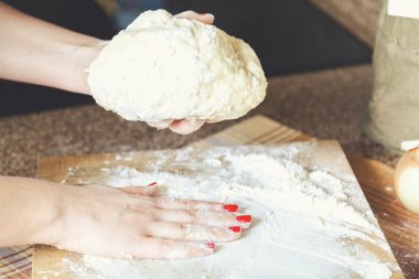 Kadın el hamur ve pürüzsüz un bir parça tahta üzerinde tutarak