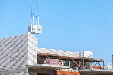yoğun yük altında inşaat ve bir tuğla baca boile inşaatı bir vinç kanca asılı