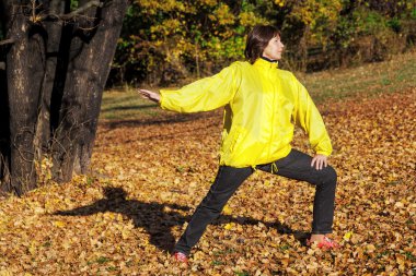 Sonbahar orman jimnastik yapıyor yaşlı güzel kadın