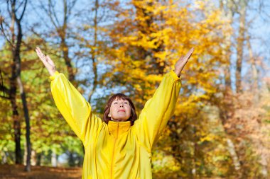 Sonbahar ormandaki egzersizleri yapıyor güzel yaşlı kadın