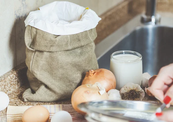 Tüte Mehl, Eier und Zwiebeln auf dem Tisch — Stockfoto