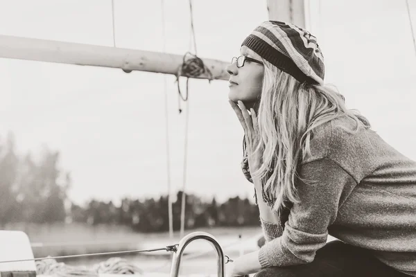 Monochrome image. Blonde in sunglasses against backdrop of mast yacht — Stock Photo, Image