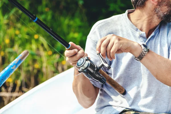 Olta ve makara kolu tutan eller balıkçı döndürülmüş — Stok fotoğraf