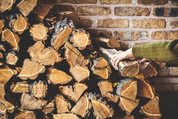 Las manos del hombre sacan troncos de leña plegada — Foto de Stock