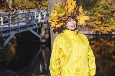 Yaşlı kadın kafasındaki yaprakların çelenk ile 