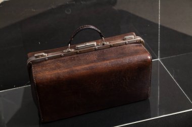Doktor antika deri çanta şeffaf bir teknenin içinde duruyor.