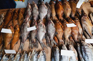 Pazarda balık serisi. Farklı cinsten kurumuş balık sürüleri tezgahın üzerinde duruyor.