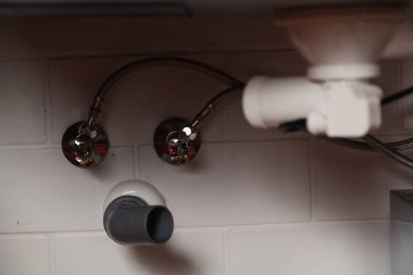 Metal mutfak lavabosunun altında parçalanmış Weir sistemi yakın plan. Yan çizgi